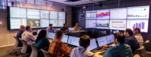 a dynamic office scene captures a diverse team of professionals gathered around a sleek conference table, intently analyzing audit reports displayed on digital screens, reflecting a vibrant atmosphere of collaboration and strategic improvement focused on enhancing operational efficiency.